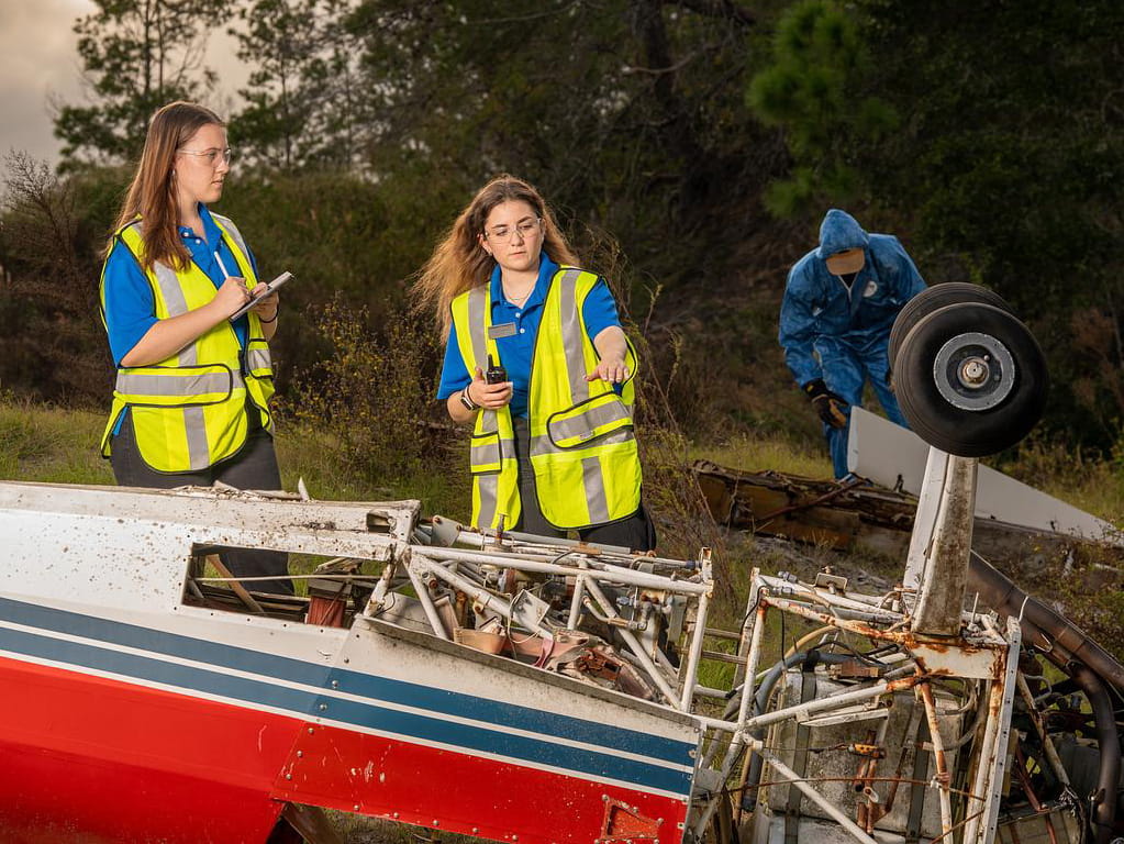 Students examine crash wreckage.