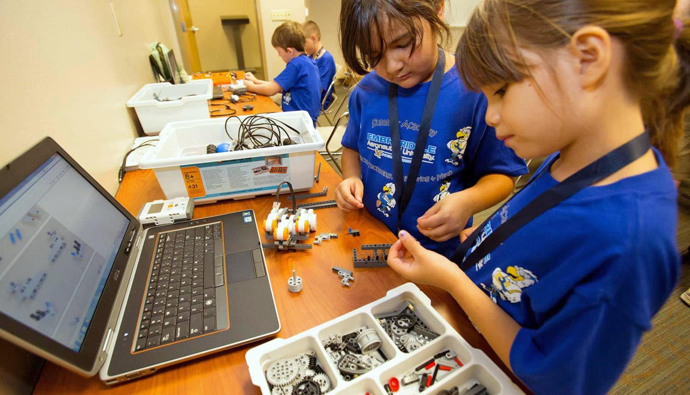 Two elementary school-aged students work together in front of a laptop computer.
