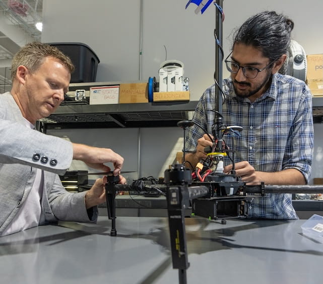 Professor and student work in drone lab