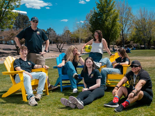 A group of students sitting outside on the grass.