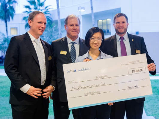 Four people holding an oversized check.