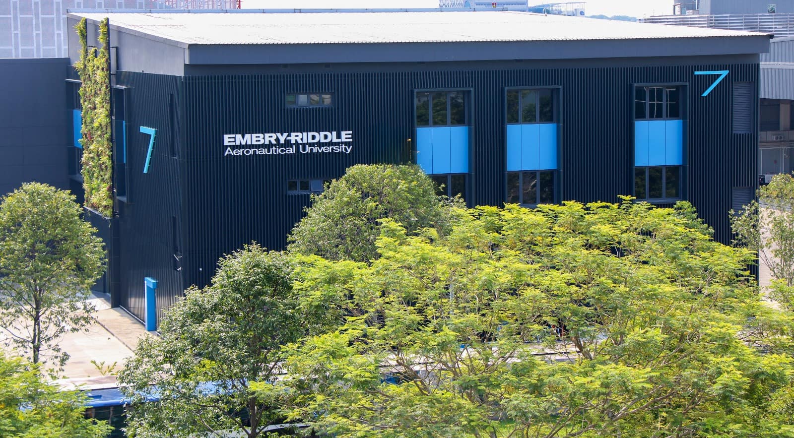 An side view of a blue building which says Embry-Riddle Aeronautical University on the side.