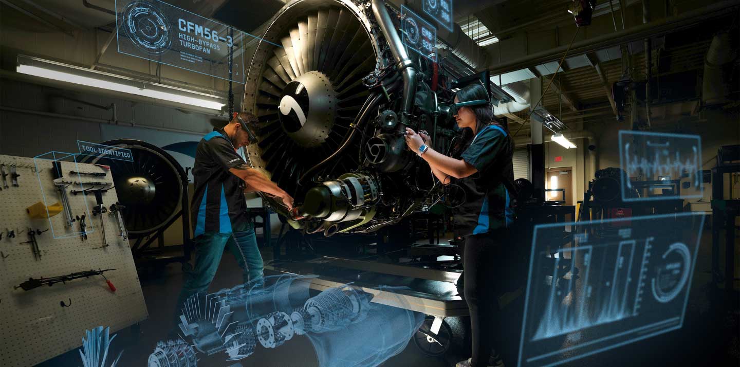 Students performing maintenance on turbofan engine in hangar with diagnostic displays and tools around work area.