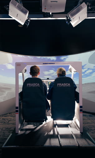 Two people in a flight simulator.