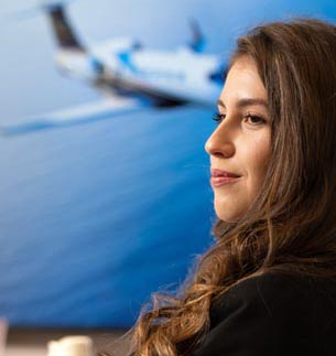 A smiling person with a photo of an airplane in the background.