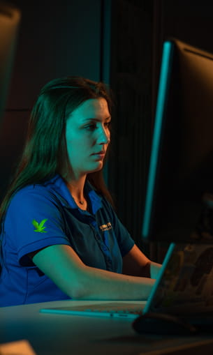 A person wearing a blue shirt and using a computer.