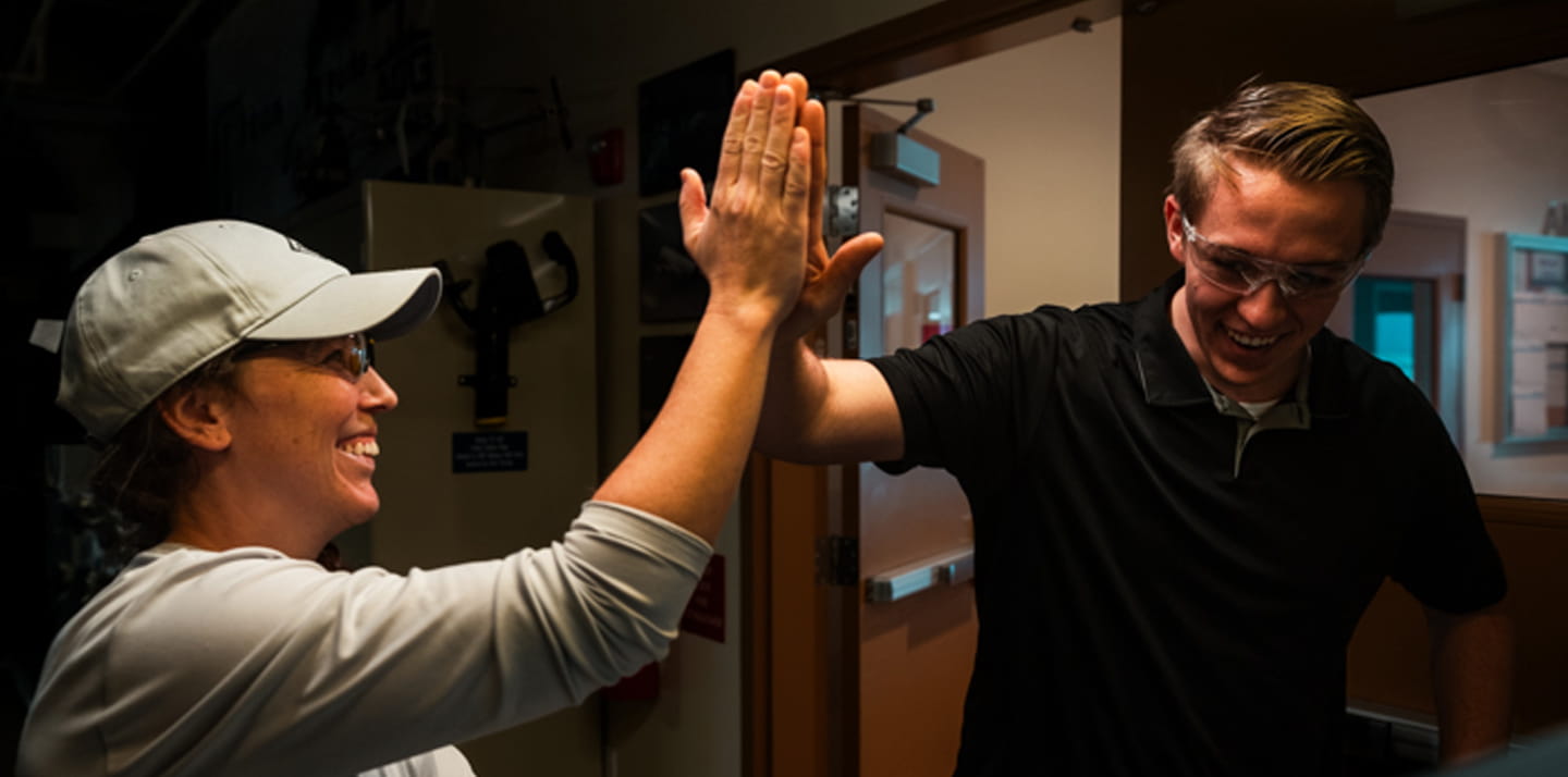 Two people giving each other a high-five.