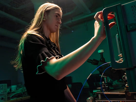 A person working on technical equipment in a laboratory setting.