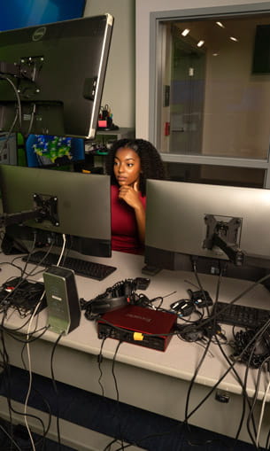 A person working on a computer with multiple monitors.