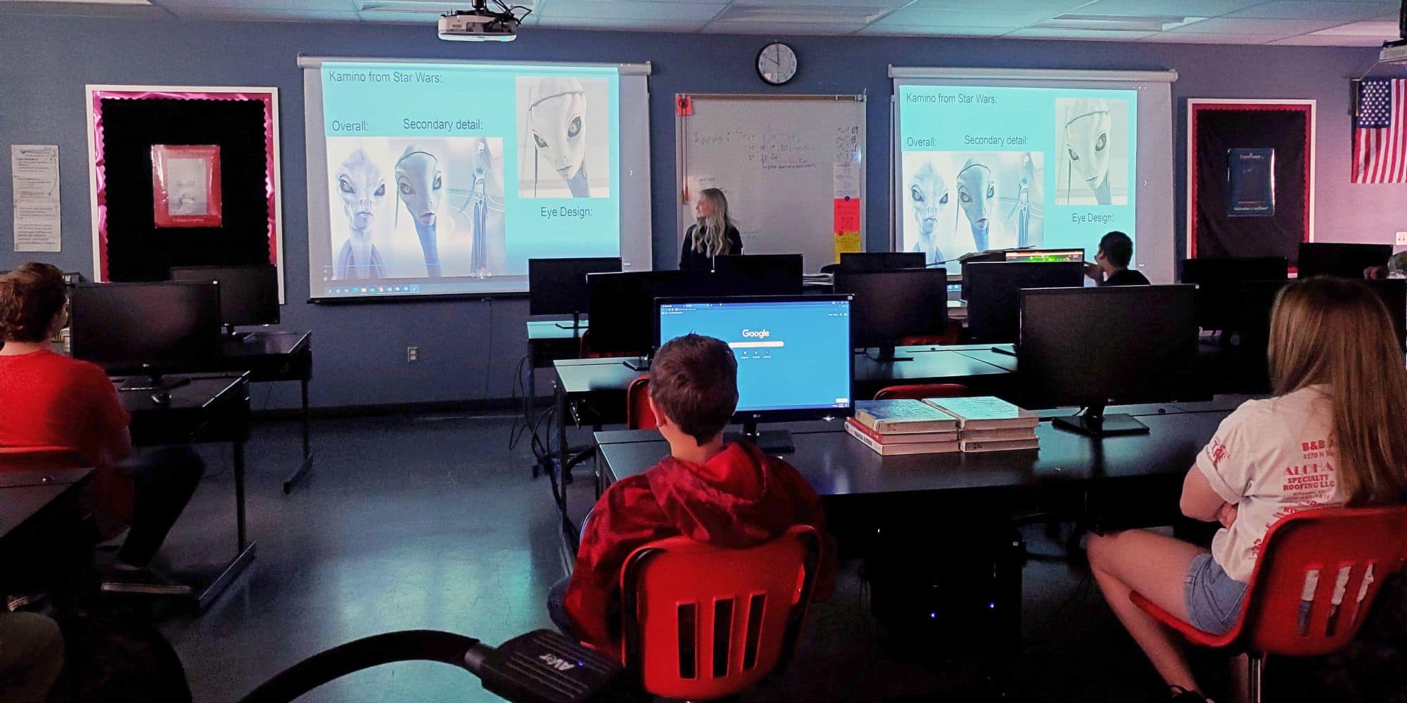Instructor presents a slide comparing character design details for 'Kamino from Star Wars' in a computer lab classroom with students seated at desktop workstations.