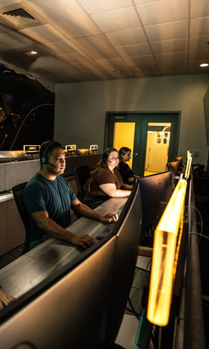 People monitor space flight displays.