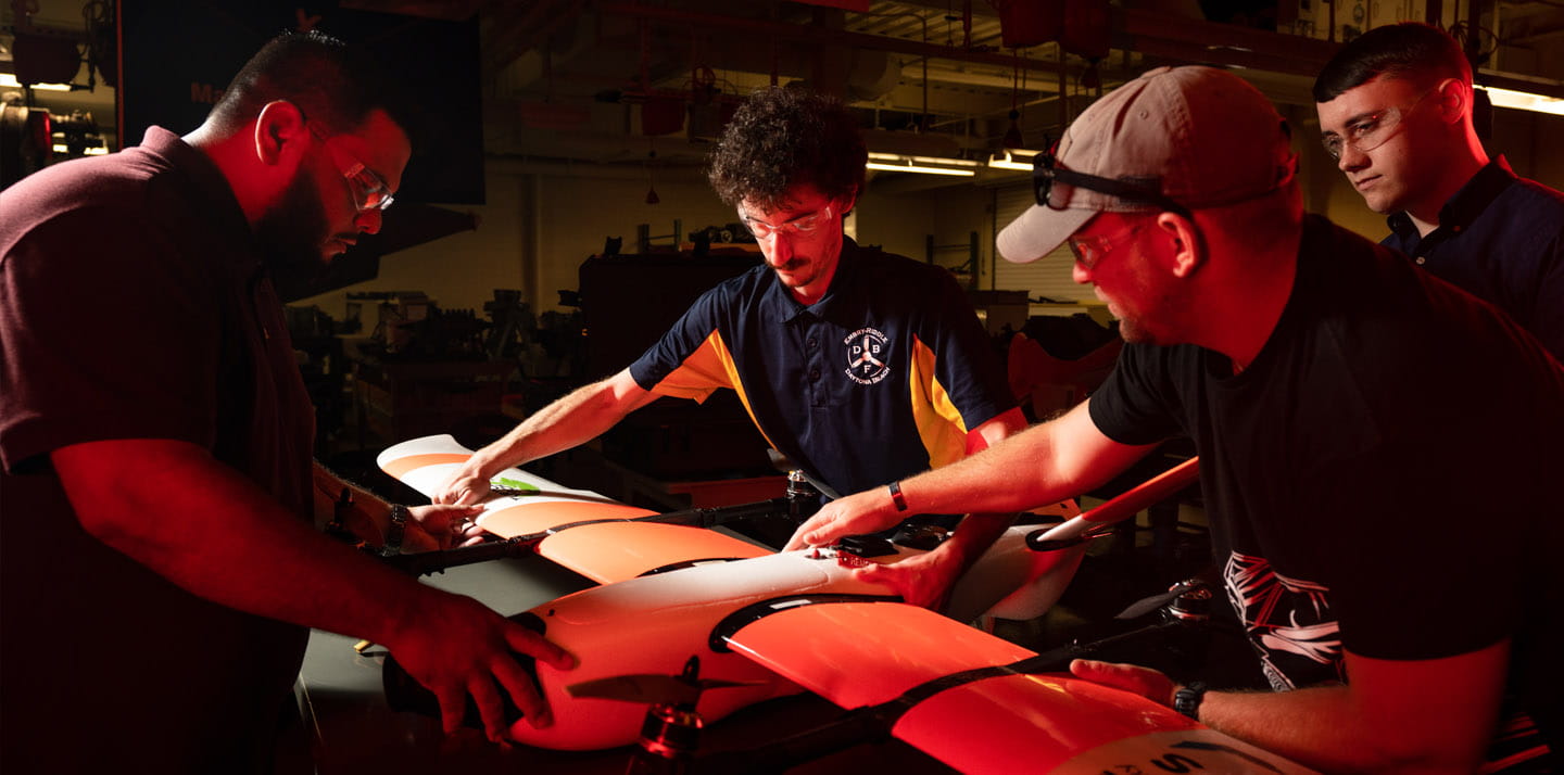 A group of people working on a white drone.