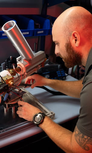 A person working on a drone in a lab setting.