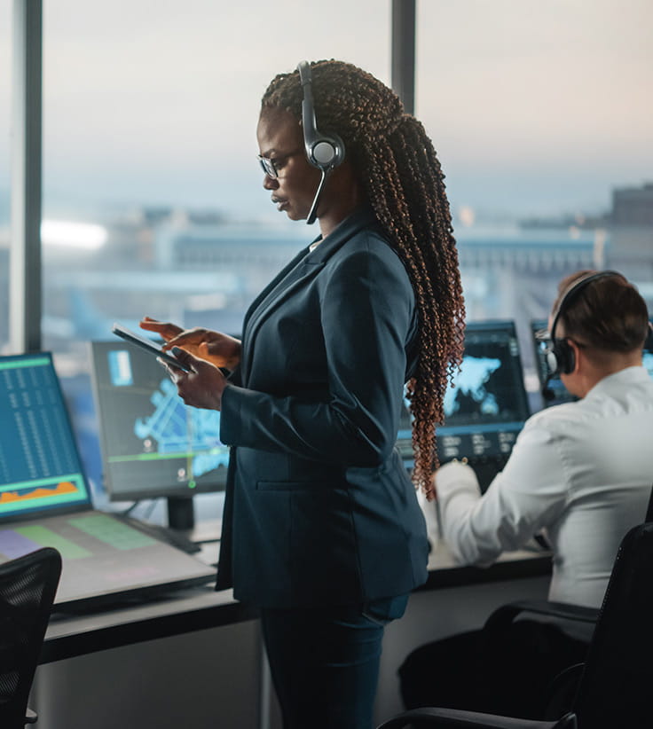 Air Traffic Controller holding tablet in airport tower.