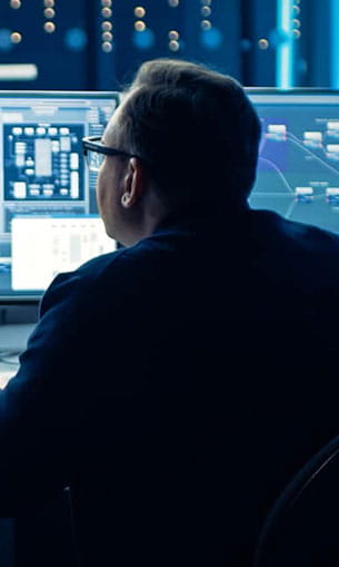 Man looking at computer monitors