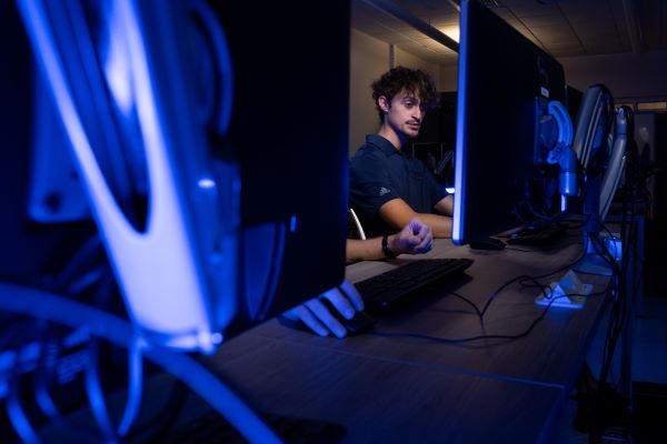 A person using a computer in a low-light setting.