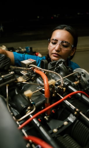 A student wearing safety glasses while working with equipment in a laboratory setting.