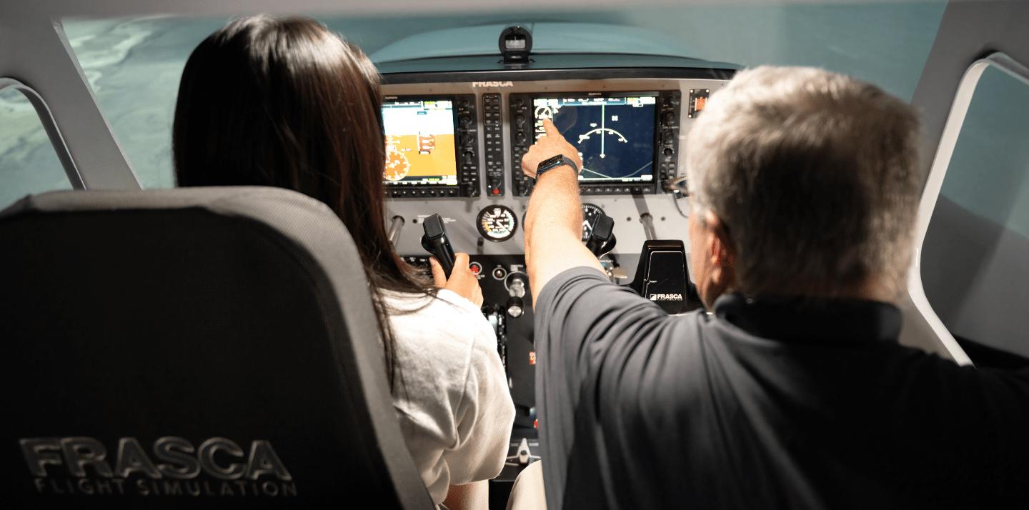 Two individuals seated side by side in the cockpit of a small airplane.