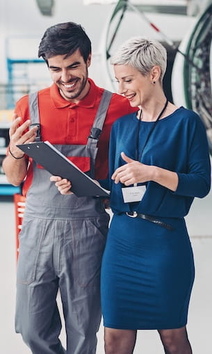 Two airline employees look at document.