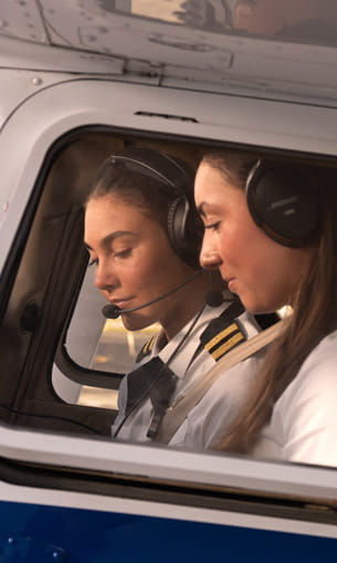 Two pilots sitting in the cockpit of an airplane.