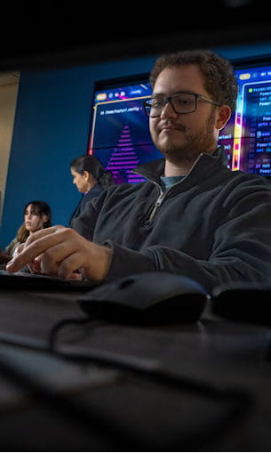 A young man types away at a computer keyboard.