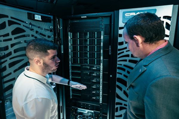 Two people are examining server equipment.