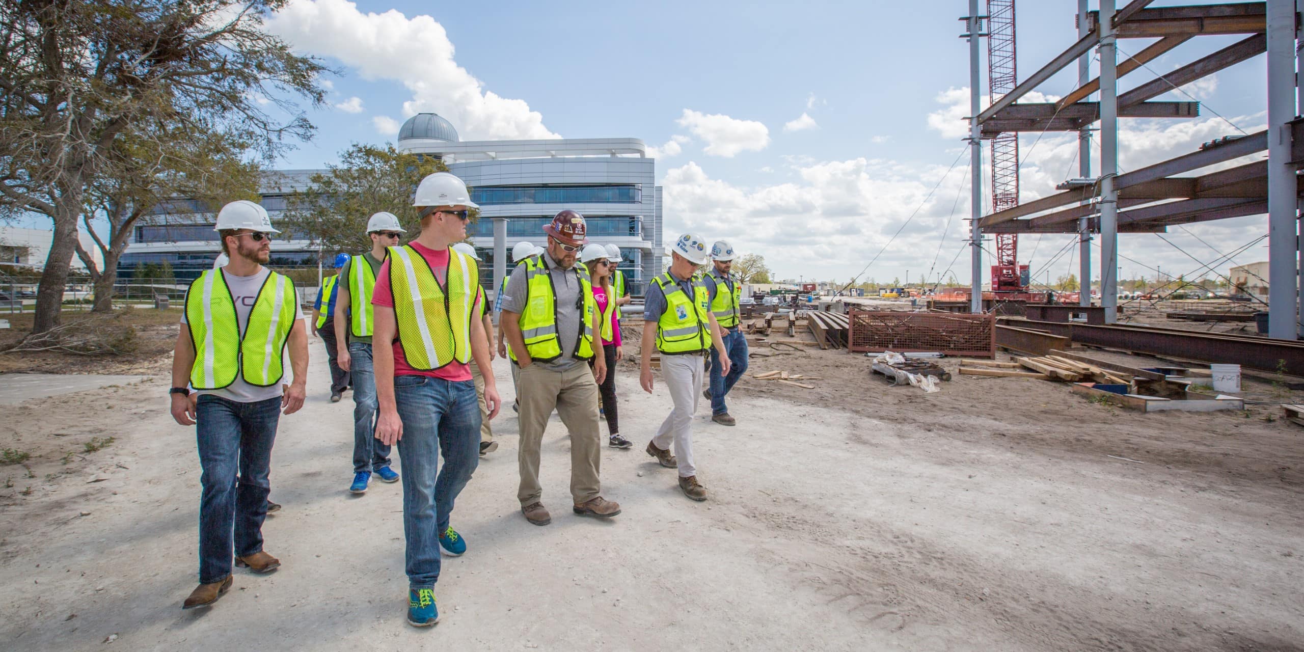 A group of construction workers walking on a construction site.