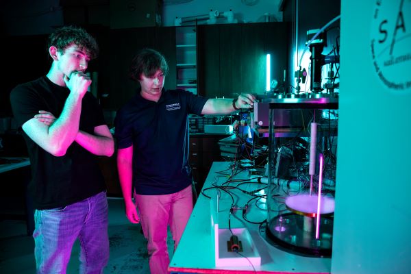 Two individuals in a lab examining equipment.