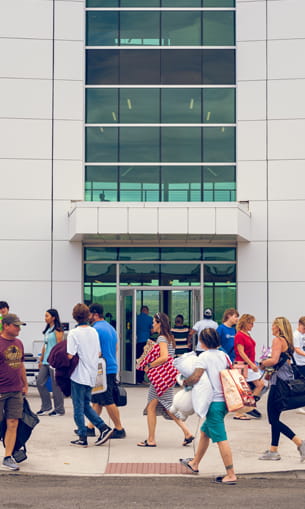 Several people walk together outdoors in front of a building.