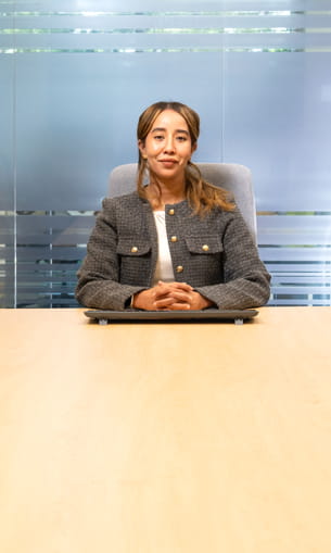 A person wearing business attire sitting at a table.
