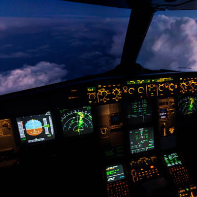 Inside an aircraft cockpit during flight, displaying its controls and instrumentation.