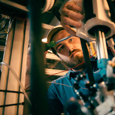 A person operating engineering equipment in a laboratory environment.
