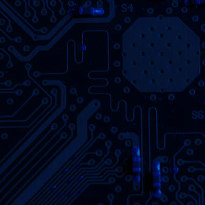 Abstract dark blue background featuring a stylized circuit board pattern with interconnected lines and nodes.