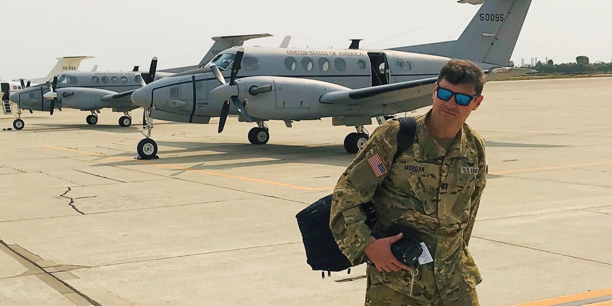 Aerospace Studies Alumnus Don Morgan ('05) standing on an airfield wearing Army fatigues.