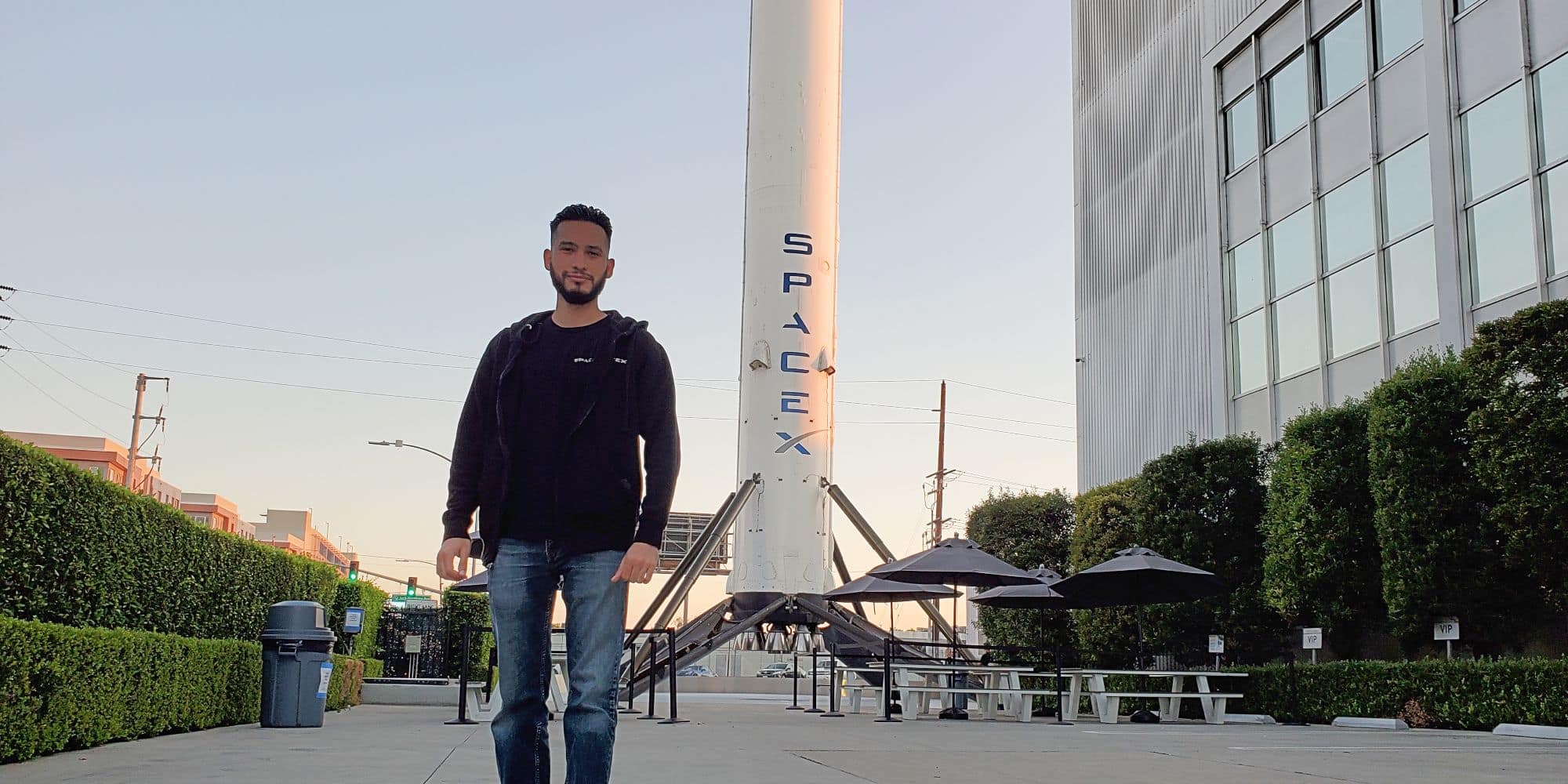 B.S. in Engineering student Marcos Dominguez stands in front of a SpaceX booster. (Photo: Marcos Dominguez)