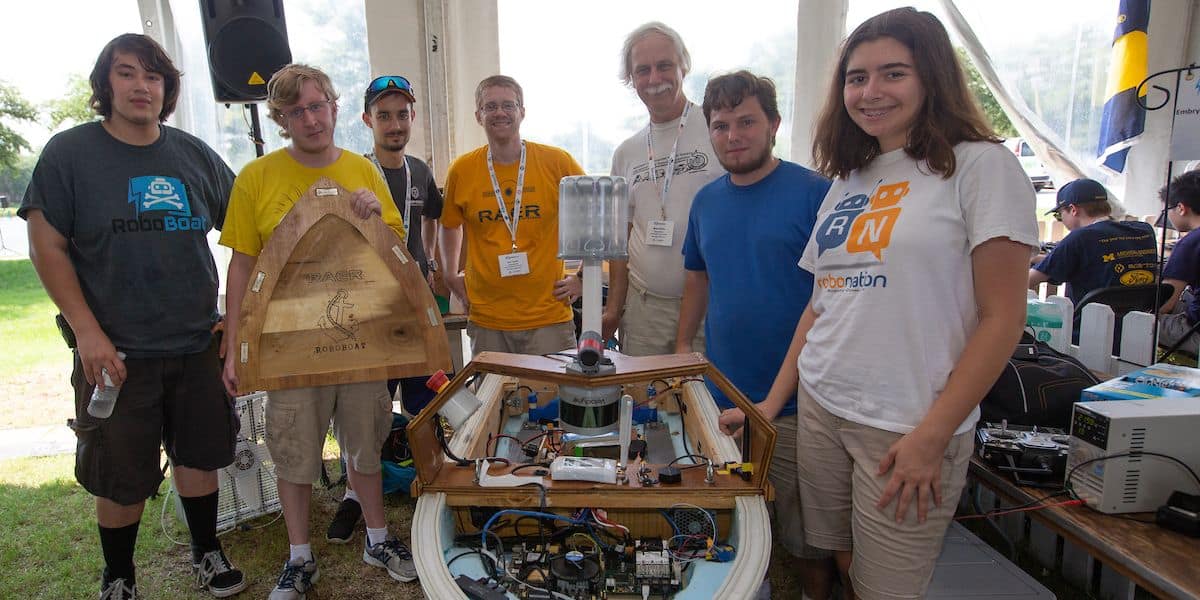 The Embry‑Riddle RAER team stand with their "Double Precision" autonomous watercraft for the AUVSI foundation's International RoboBoat Competition.