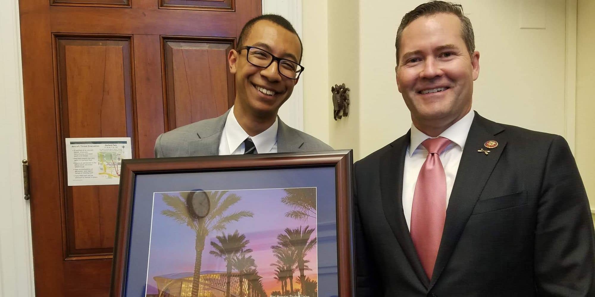 Dwayne Clark holds a photo of Embry‑Riddle's student union with Rep. Michael Waltz (FL-6). (Photo: Dwayne Clark)