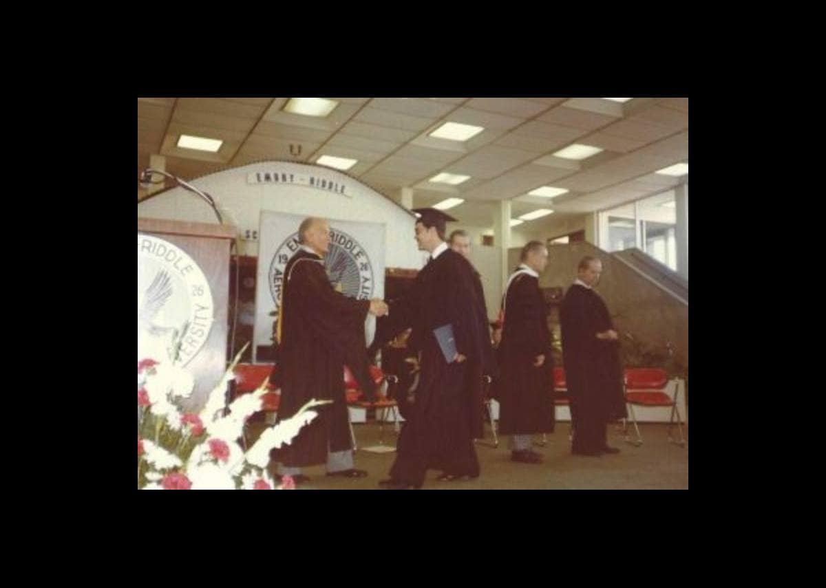 Upon receiving his diploma, Alcock walks across the stage to shake hands with Embry‑Riddle co-founder John Paul Riddle. (Photo: Ralph Alcock) 