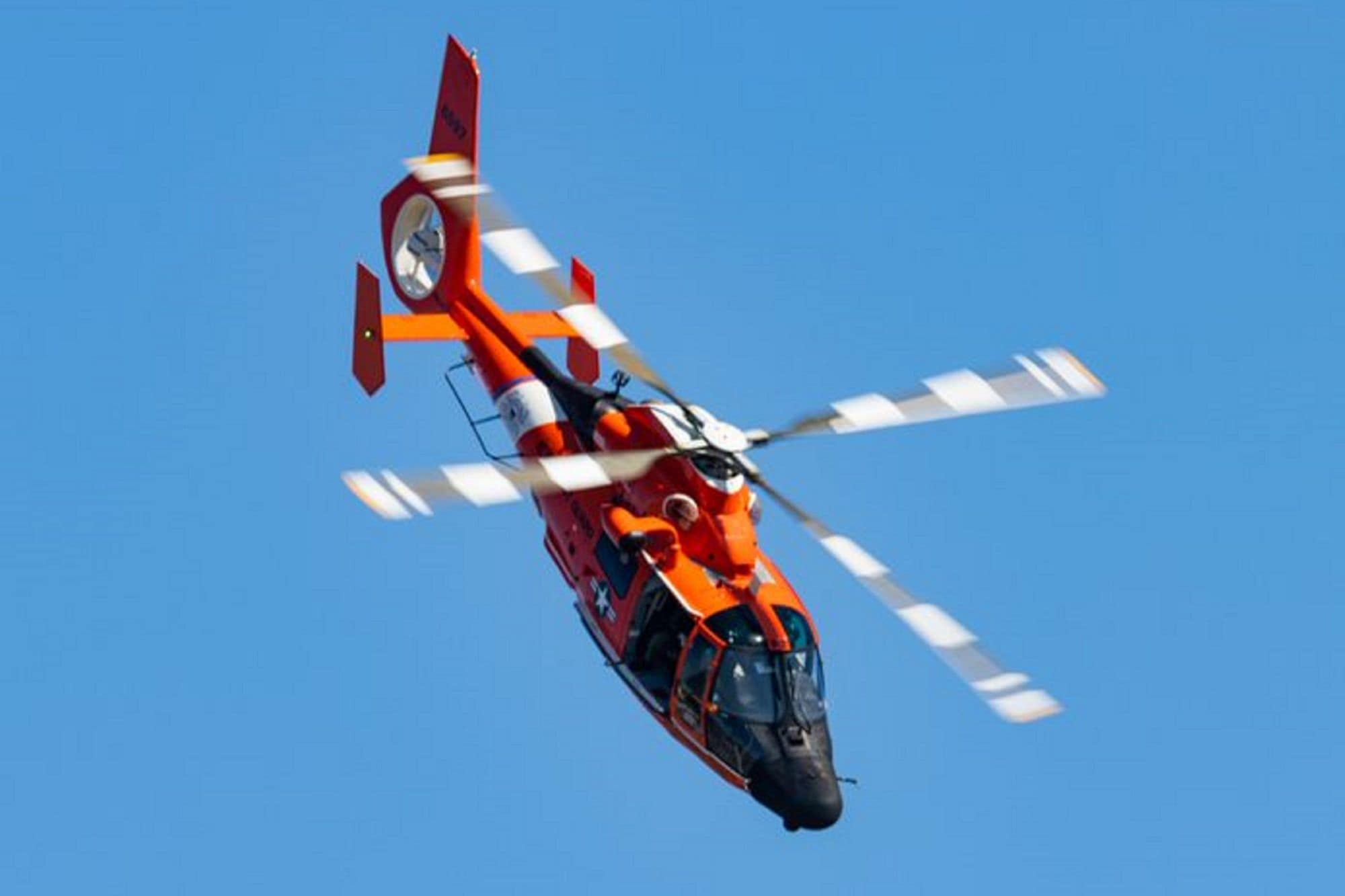 A Coast Guard helicopter set against the blue Florida sky in a photo taken from above. (Photo: Bastien Melin via @ocular.photo on Instagram)