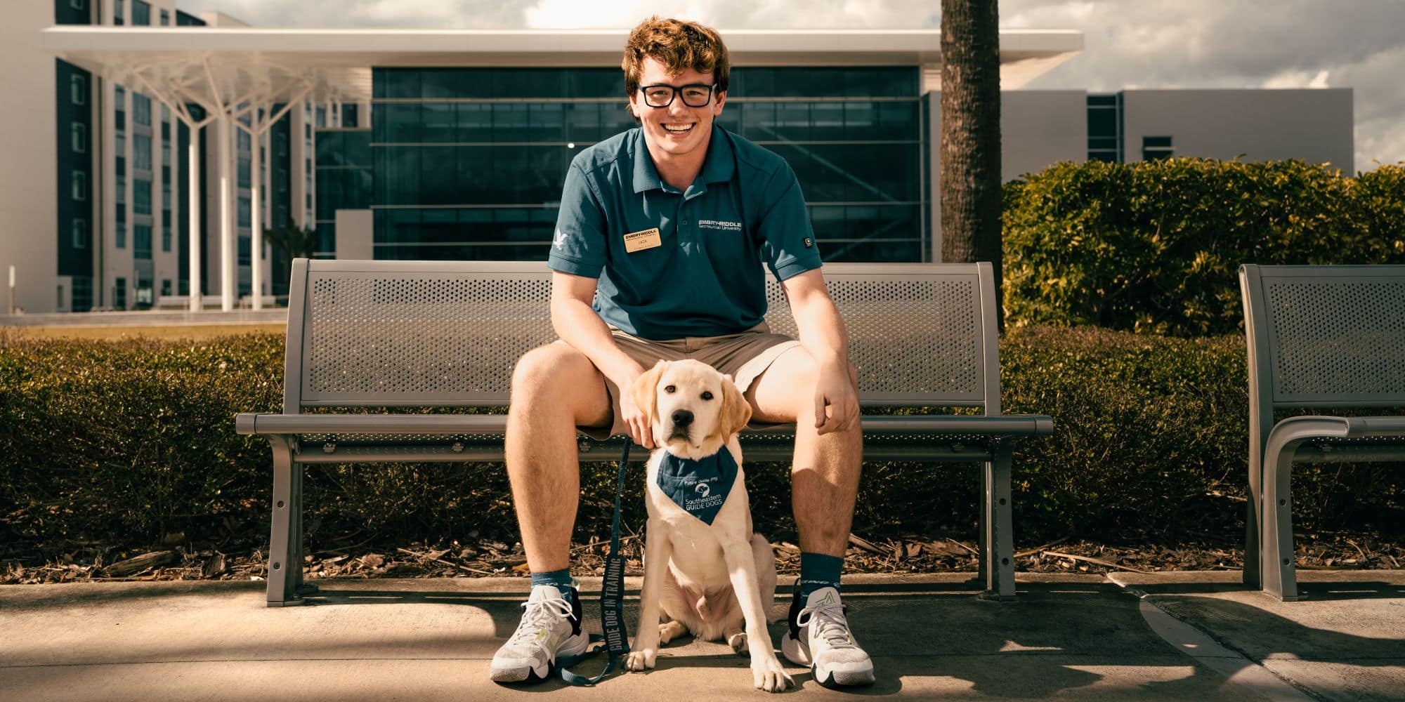 Jack Frankie ('25) with Harrison the Guide Dog who is training to be a future guide dog at the Daytona Beach Campus. (Photo: Embry‑Riddle / Joseph Harrison)