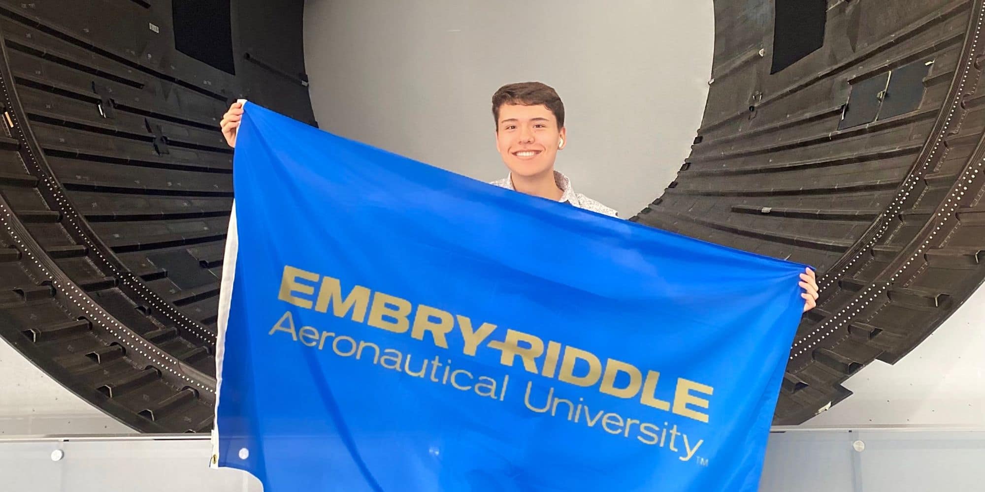 During at his summer internship at NASA, Connor Arnold took a minute to show off the Embry-Riddle flag as he stood in front of a rocket engine. (Photo: Connor Arnold)