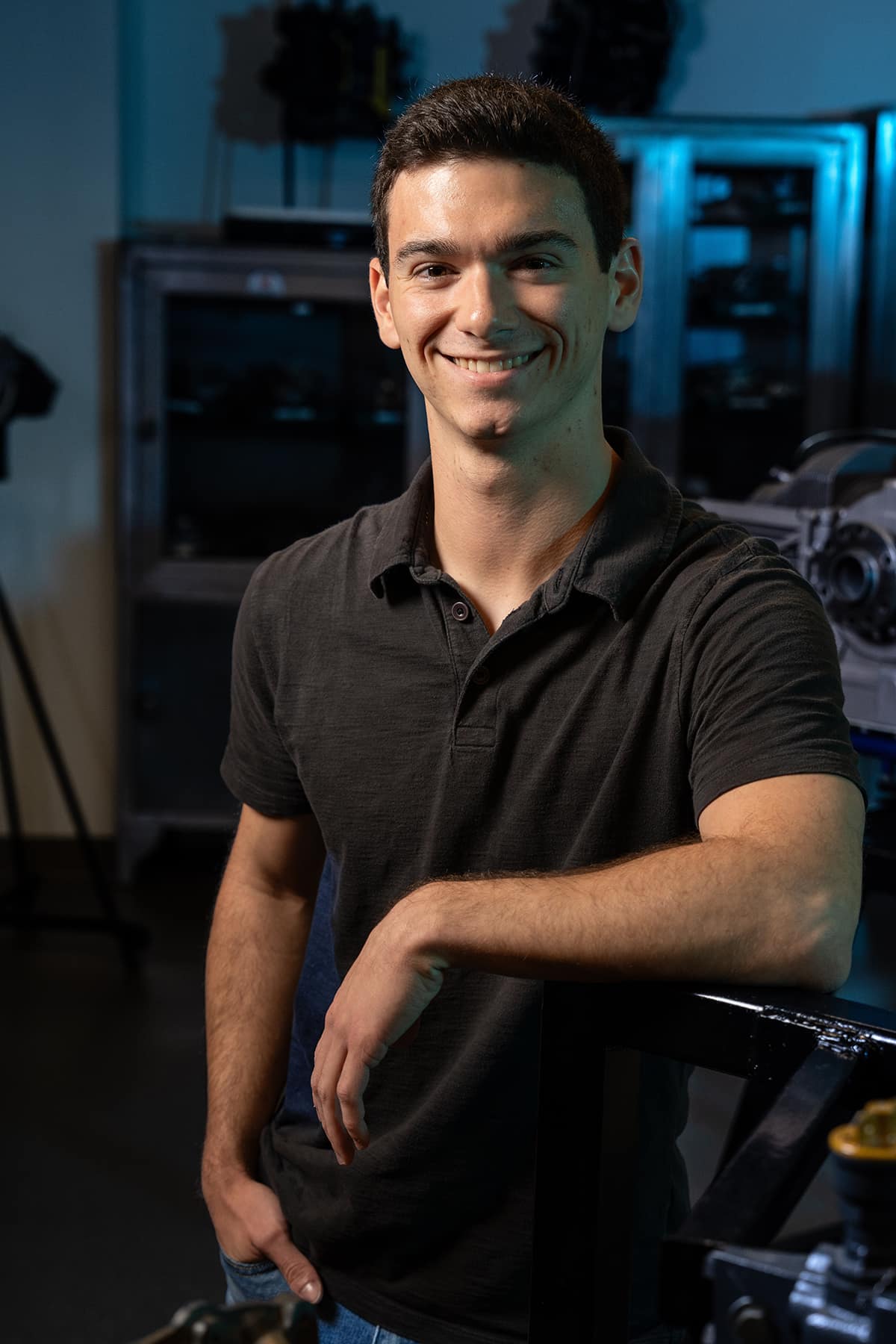 Nicolas Napoleoni poses in a dark polo shirt in a darkened maintenance hangar.