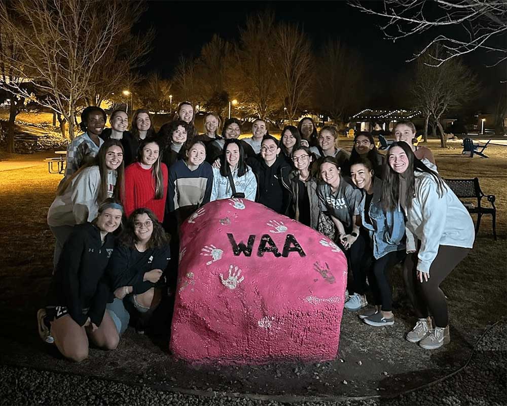 Makenzi Patterson and members of the WAA gather on Embry‑Riddle's Prescott Campus after painting the Spirit Rock. (Photo: Makenzi Patterson)