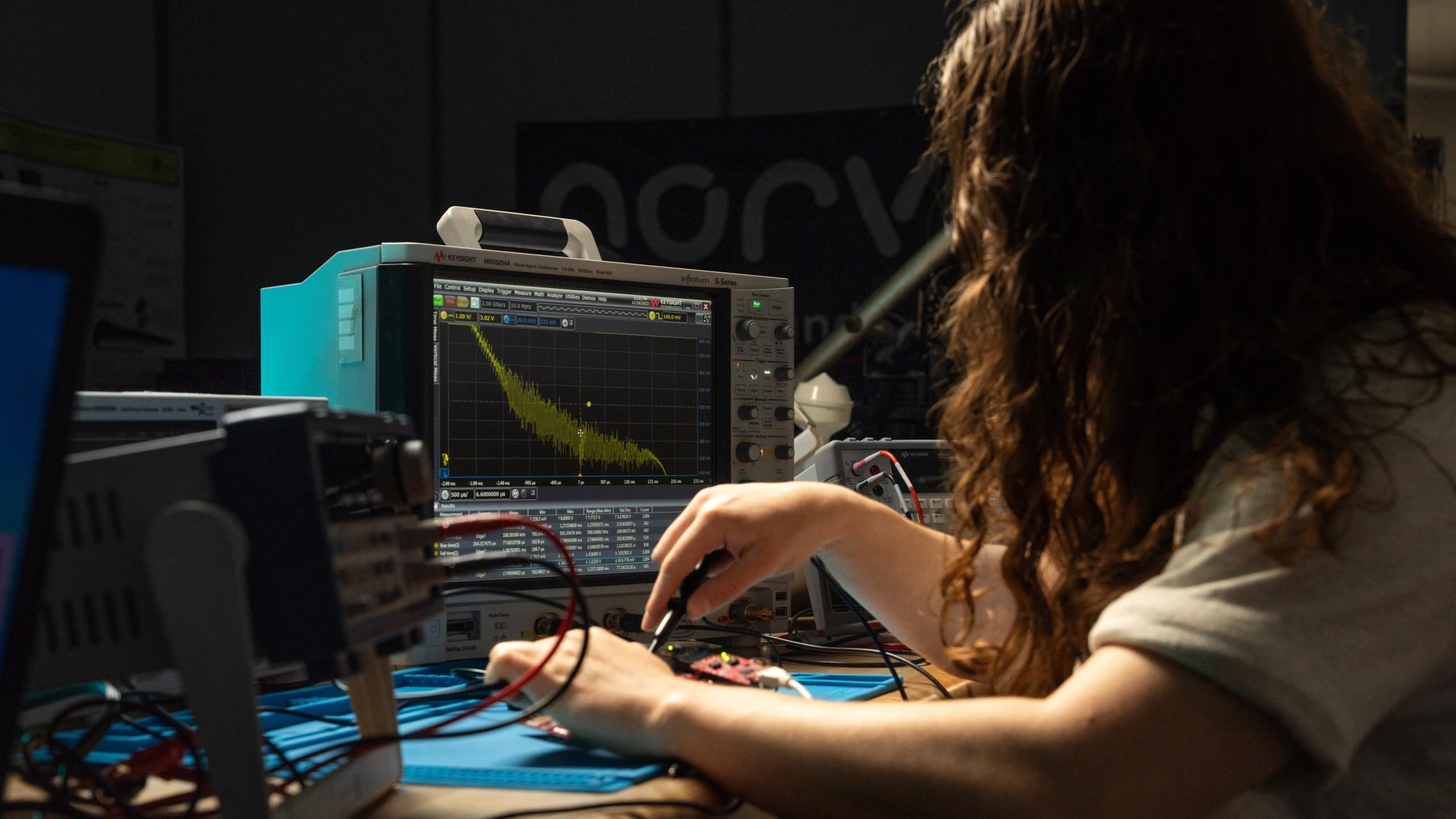 Student works with a soldering iron on a circuit board in front of a Keysight oscilloscope in the Circuits, Sensor and Instrumentation Laboratory.