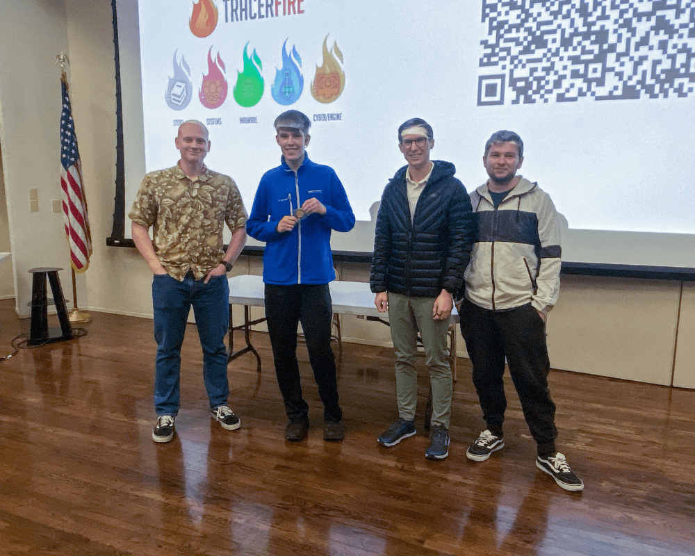 1. Aaron Tulino, holding his medal, stands near the center of the group, having earned the highest individual score at the Tracer FIRE competition.