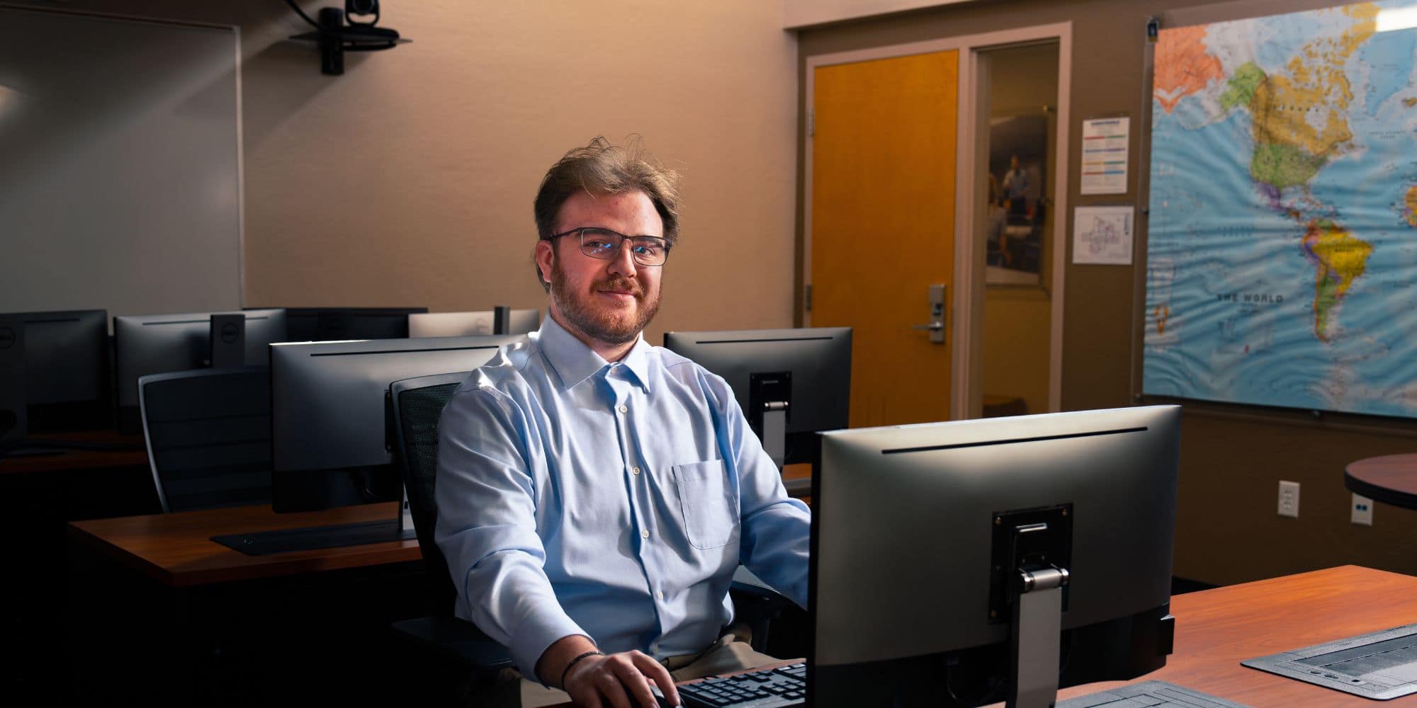 Riley Grant sitting in a computer lab on the Prescott Campus.