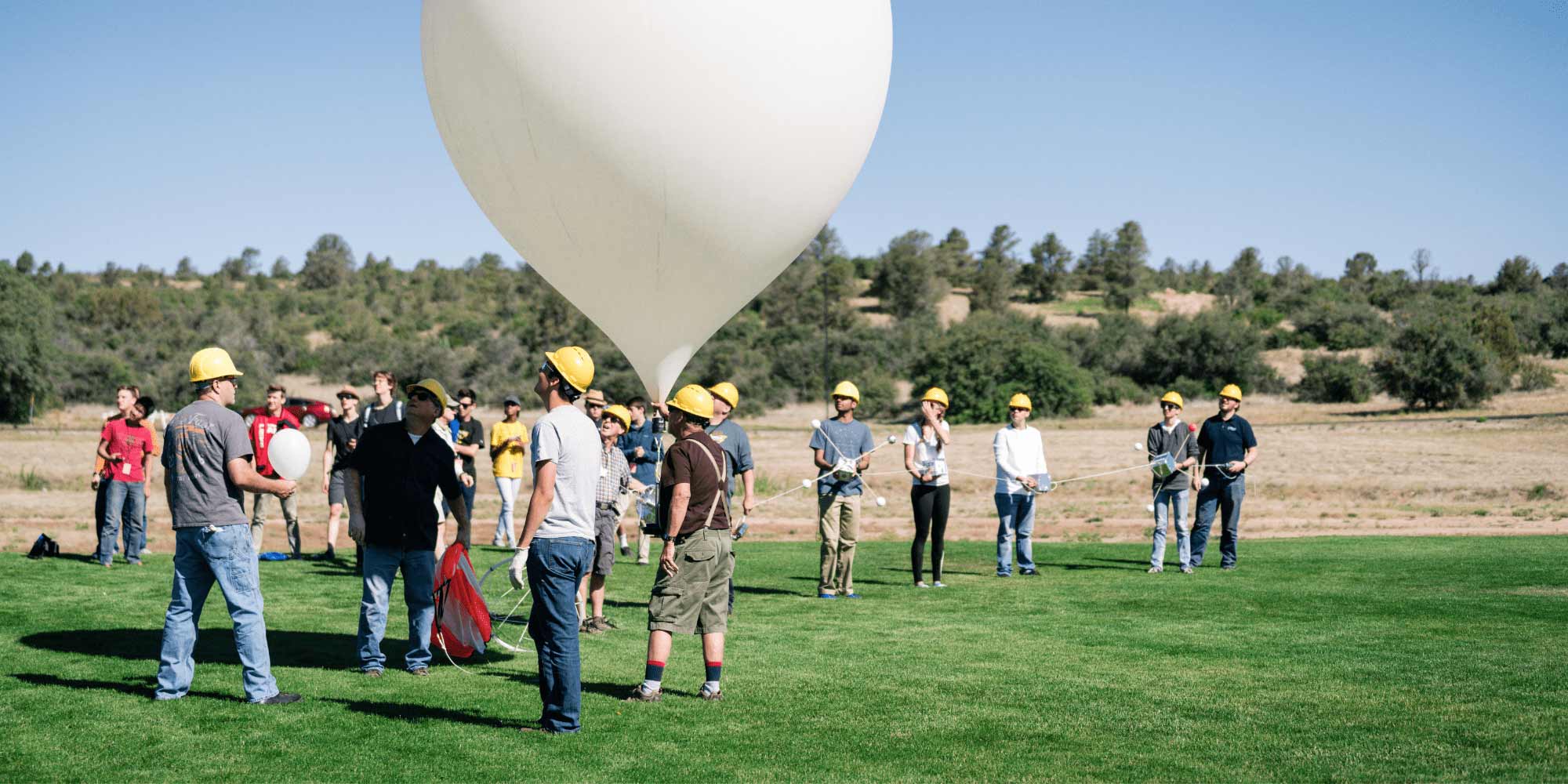 Summer camp attendees watch a weather balloon take flight.