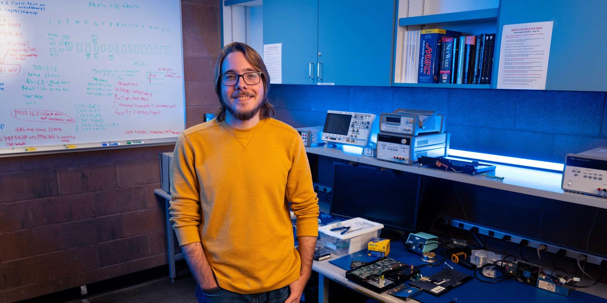 Embry‑Riddle student Michael Stalford stands in the senior design lab smiling, proud of the hard work he’s invested to get where he’s at in Embry‑Riddle's Electrical Engineering program.