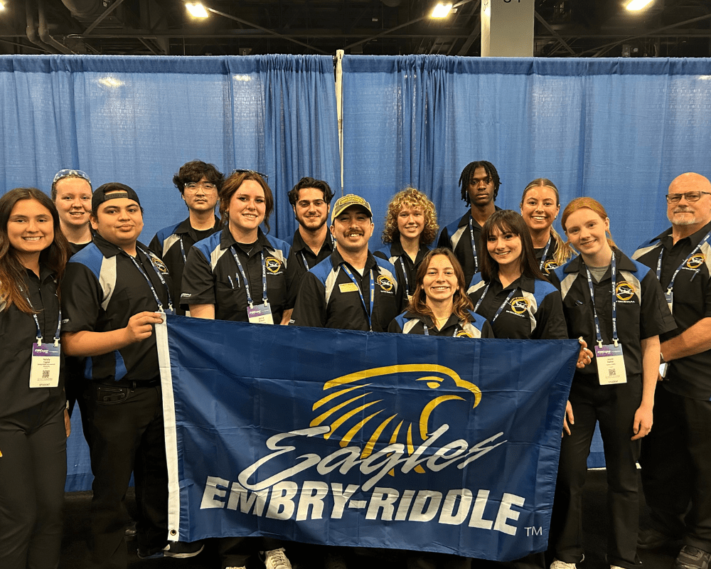 Students pose with ERAU banner.