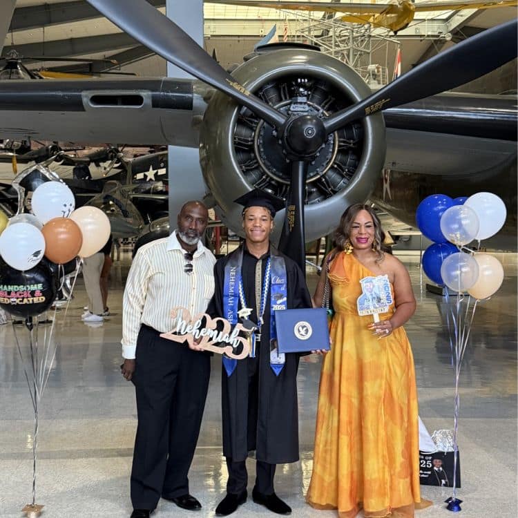 Nehemiah Ash, a dual-enrolled high school student, celebrates earning his Associate in Aeronautics alongside his proud parents at a historic aviation museum.